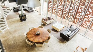 Una sala de estar moderna con una mesa redonda de madera, un sofá y una chimenea.