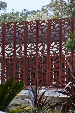 A red metal fence with cut-out patterns.