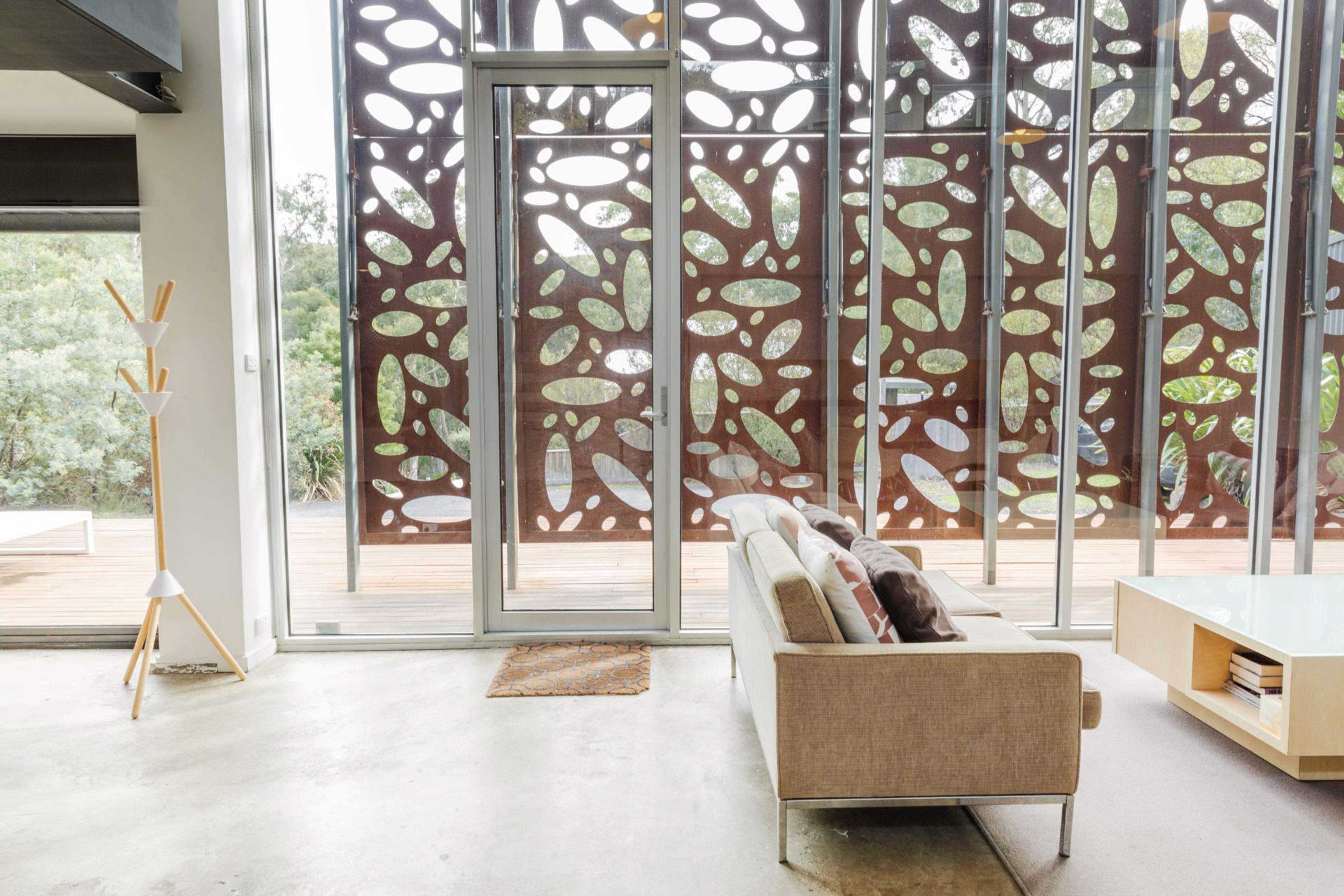 A modern interior with a sofa, a coffee table, and a decorative wall with abstract patterns.