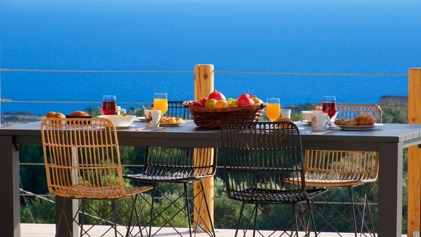A table set with breakfast items and a view of the ocean. - Exclusive Sea View Villa Madelaine (SPARTIA)