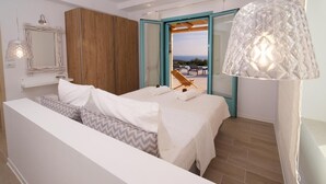 A modern bedroom with a large bed, a wooden wardrobe, a bathroom with a glass door, and a view of the outdoors. - Exclusive Sea View Villa Madelaine (SPARTIA)