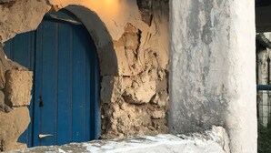 A weathered stone wall with a blue door partially obscured by an archway. - Beautiful quiet villa (4p), private pool and great sea views (Kirianna)