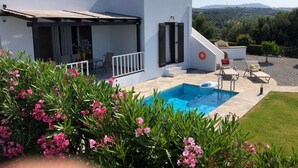 A modern villa with a swimming pool, outdoor seating, and a view of the countryside. - Beautiful quiet villa (4p), private pool and great sea views (Kirianna)