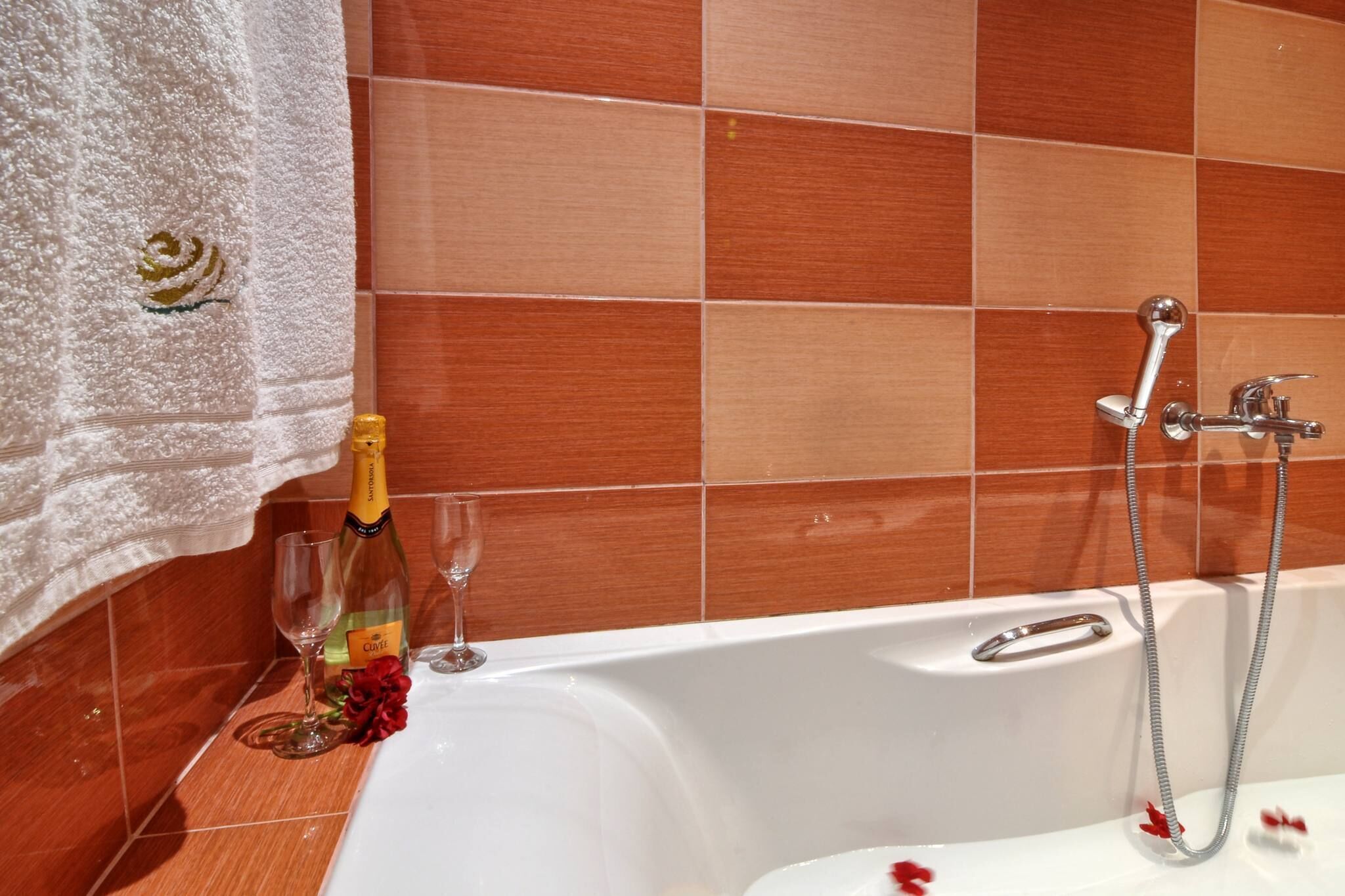 A bathroom with a bathtub, a shower, and a towel rack.