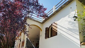 A staircase leading to a white building with a tiled pattern, a wooden door, and a metal railing. - Self catering Barranco de la Salud for 11 people (Nevada)