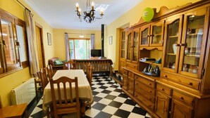 A dining area with a checkered floor, wooden furniture, and a cabinet with glass doors. - Self catering Barranco de la Salud for 11 people (Nevada)