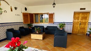 A cozy living room with a sofa set, a wooden coffee table with a potted plant, and a tiled wall with a decorative border. - Self catering Barranco de la Salud for 11 people (Nevada)