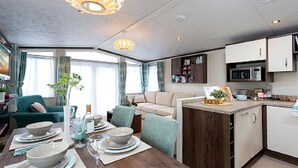 A modern interior with a dining area, kitchen, and living space. - 2 Bed Caravan, South Devon Coast nr Plymouth, 200m to Beach + Indoor Heated Pool (PLYMOUTH)