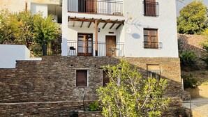 A two-story building with a stone facade and multiple windows. - Self catering Barranco de la Salud for 2 people (Nevada)