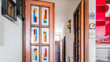Un corridoio con una porta in legno decorata con pannelli di vetro colorati.