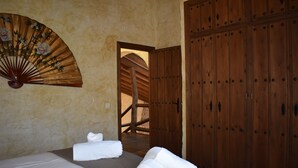 A room with two beds, a wooden wardrobe, and a fan with floral design. - Finca Ortiz with private pool for 6 people and fantastic views (Cómpeta)