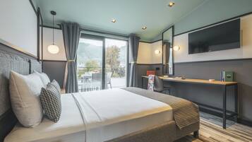 Een moderne hotelkamer met een groot bed, een bureau en een aan de muur bevestigde televisie.