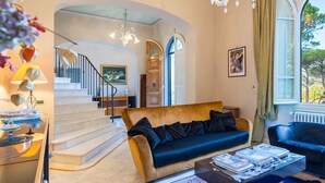 A spacious living room with a sofa, coffee table, and a staircase leading to another level. - Villa Leonardo 30+6, Emma Villas (Figline e Incisa Valdarno)