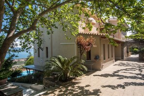 A building with a pool, surrounded by trees and a view of the sea. - Villa Panorama with Sea View and common Swimming Pool (Selianitika)