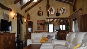 A cozy living room with a white leather sofa, wooden coffee table, and a television on a wooden cabinet. - Finca Durillo with private pool for 6 people (Competa)