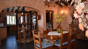 A rustic dining area with wooden furniture, a chandelier, and a vase with flowers. - Finca Higueron with private pool for 6 people and fantastic views (Competa)