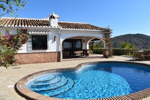A house with a swimming pool, a patio with outdoor furniture, and a mountainous backdrop. - Finca Higueron with private pool for 6 people and fantastic views (Competa)