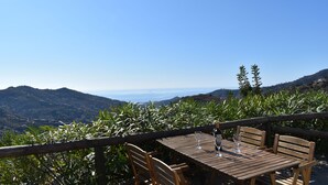 A wooden table with two chairs and a wine glass on a terrace overlooking a mountainous landscape. - Finca Higueron with private pool for 6 people and fantastic views (Competa)