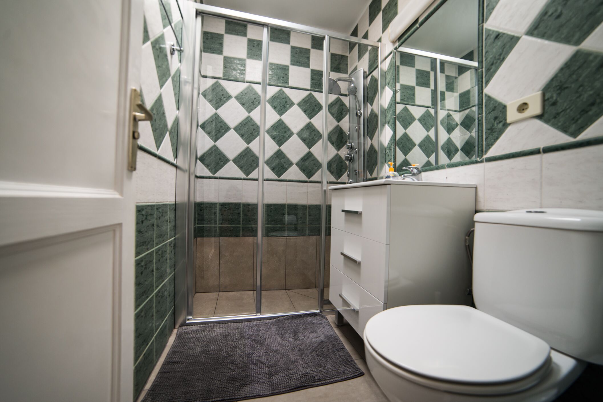Un baño con ducha, inodoro y lavabo.