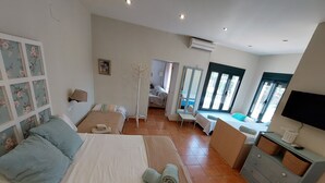 Una camera d'albergo con un letto, una scrivania, una sedia, una televisione e una finestra.