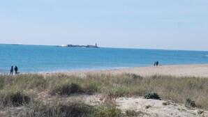 Una spiaggia con vista libera sul mare e un'isola all'orizzonte.