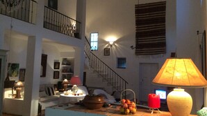 A spacious living area with a staircase, a dining table with a lamp, and a basket of fruits. - Charming country house in Silves. (Silves)