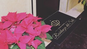 Un letrero negro con letras doradas que dice "Residencia del Sol" en el vestíbulo de un hotel.