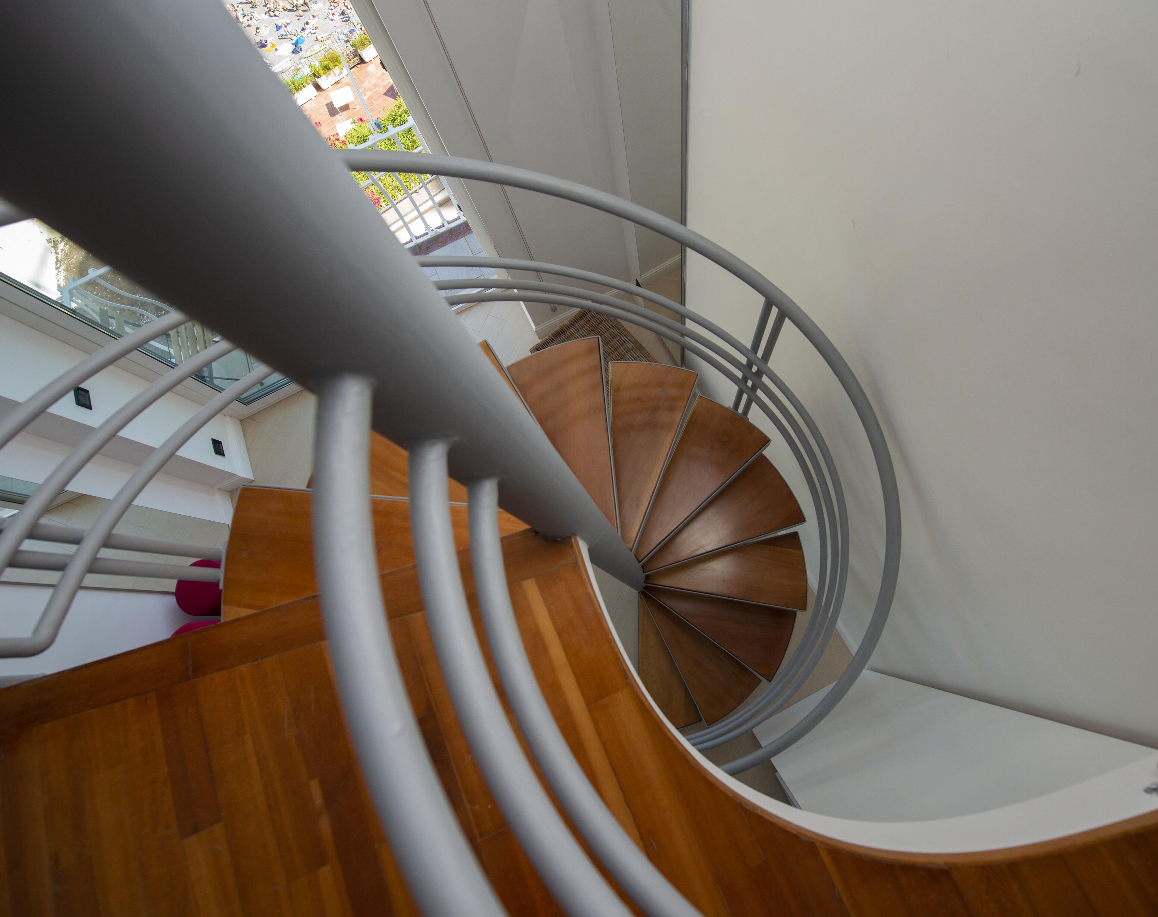 A spiral staircase with wooden steps and a metal railing.