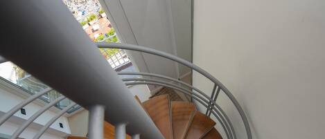 A spiral staircase with wooden steps and a metal railing.