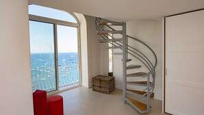 A room with a spiral staircase, a large window with a view of the sea, and a red bench. - Casa Margherita ..... Positano, perfect location for your holiday in Positano (Positano)