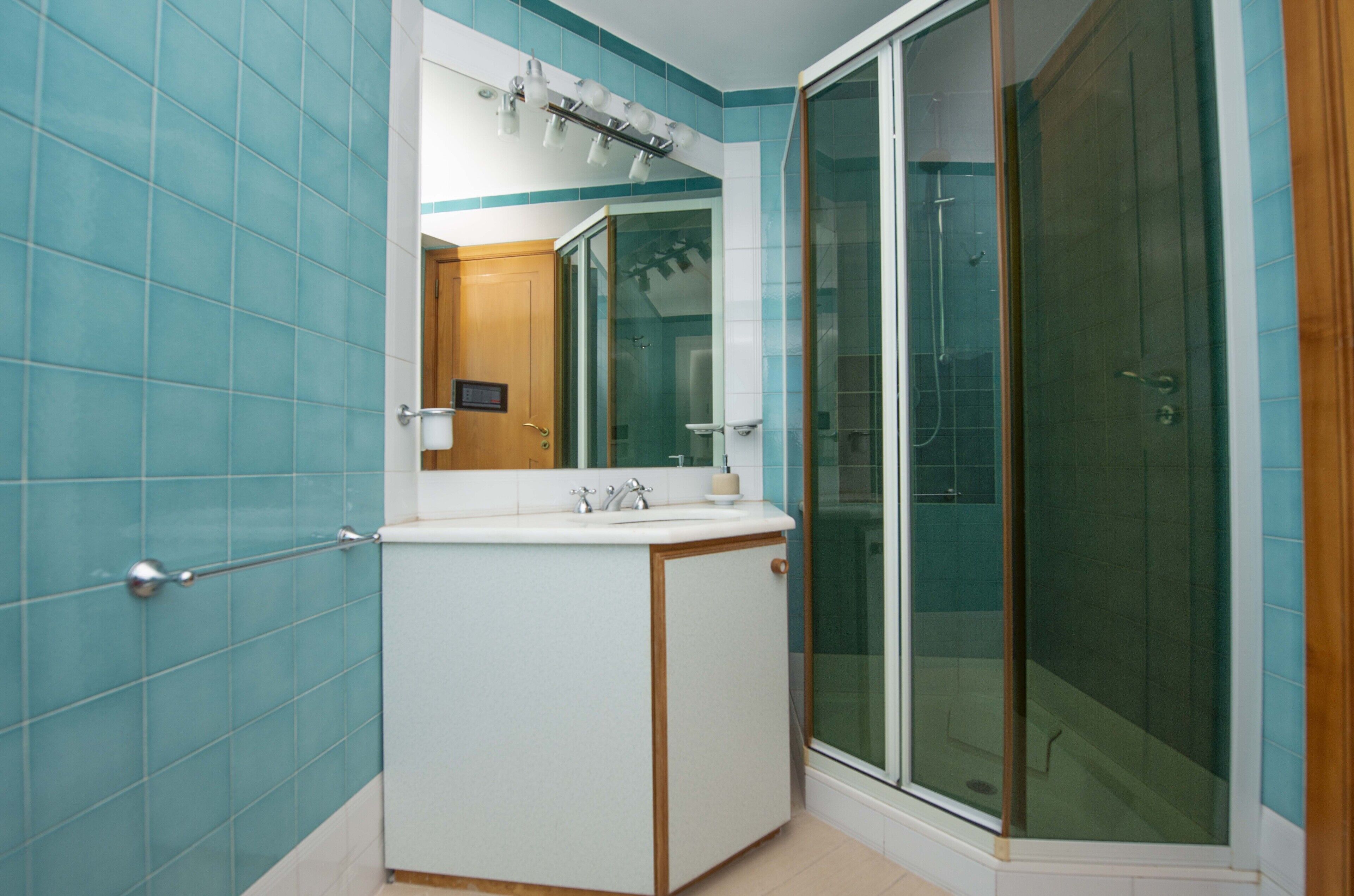A bathroom with a shower, a sink, and a mirror.