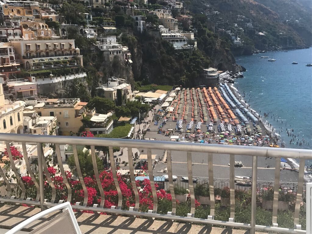 Une ville côtière avec une plage bordée de parasols et de gens.