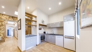 Una cucina moderna con mobili bianchi, forno integrato e frigorifero.