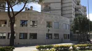 A multi-story building with a modern architectural style, featuring a mix of rectangular and square windows, and a flat roof. - In Matera "Sotto i pini" - COMFORT AND NEAR THE SASSI (Matera)