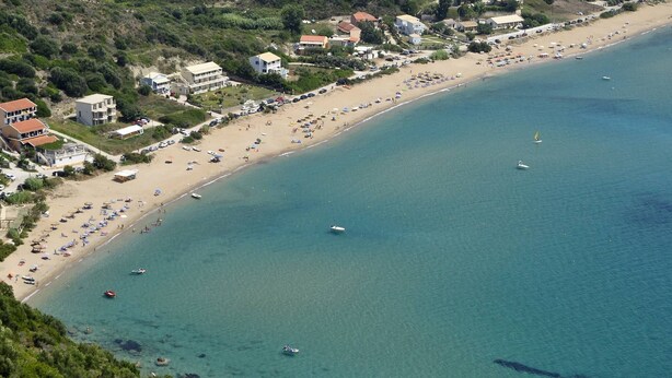 Eine Luftaufnahme einer Küstenregion mit Strand, Booten und Gebäuden.