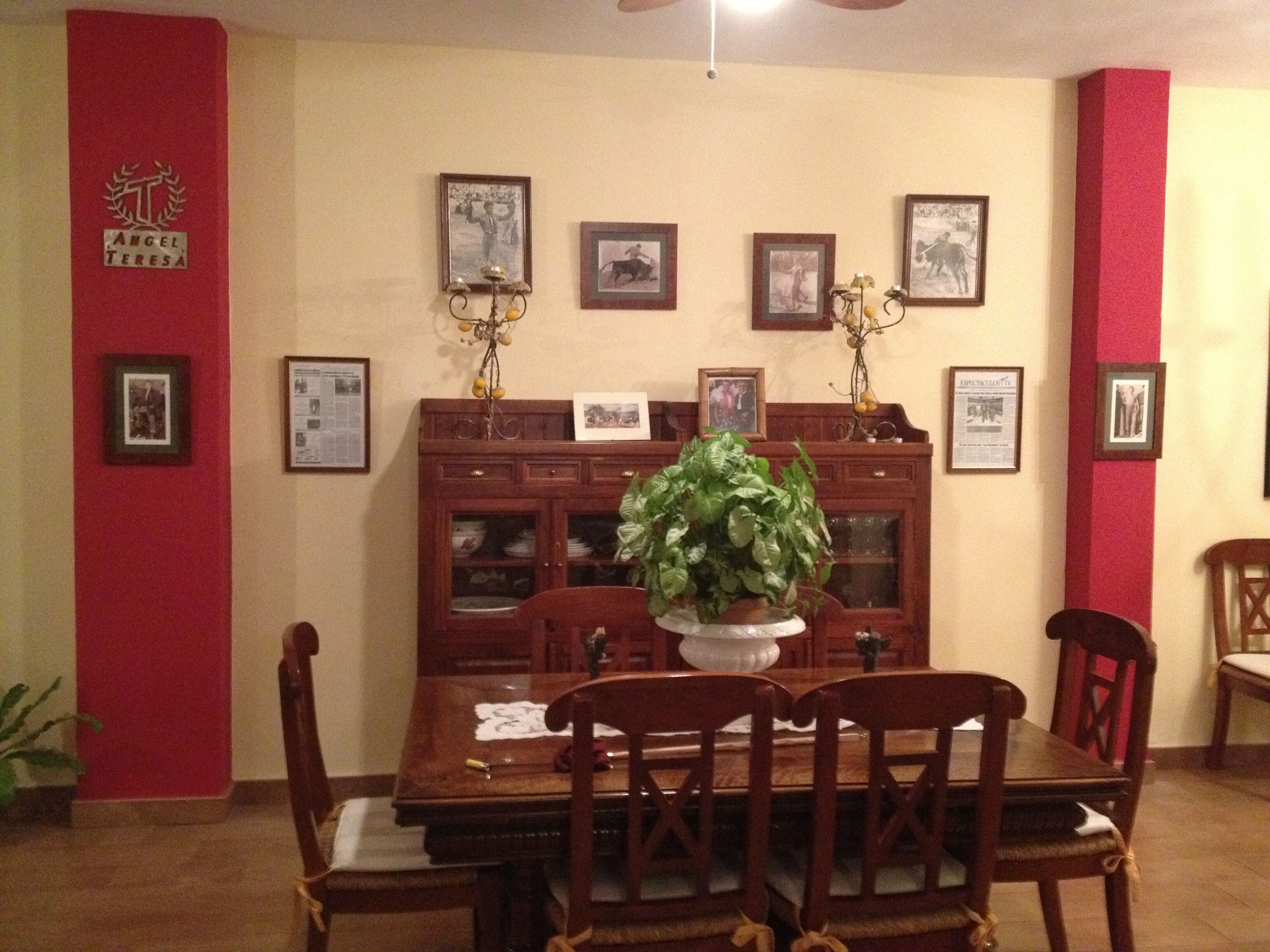 A dining area with a wooden table, chairs, and a potted plant.