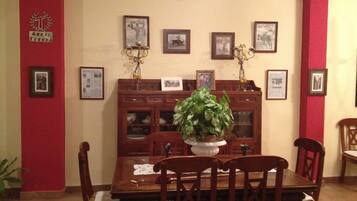A dining area with a wooden table, chairs, and a potted plant.