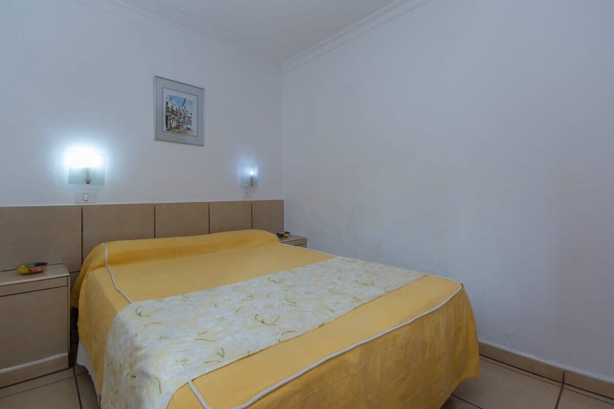 Ein Schlafzimmer mit einem Bett, Nachttischen und Wandleuchten.