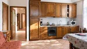 A kitchen with wooden cabinets, a microwave, and a stove. - Farmhouse in Chianti (gaiole in chianti)