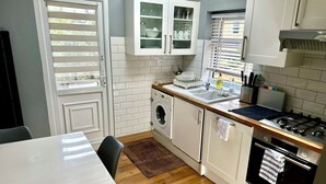 Una cocina funcional con lavadora, estufa y pileta.