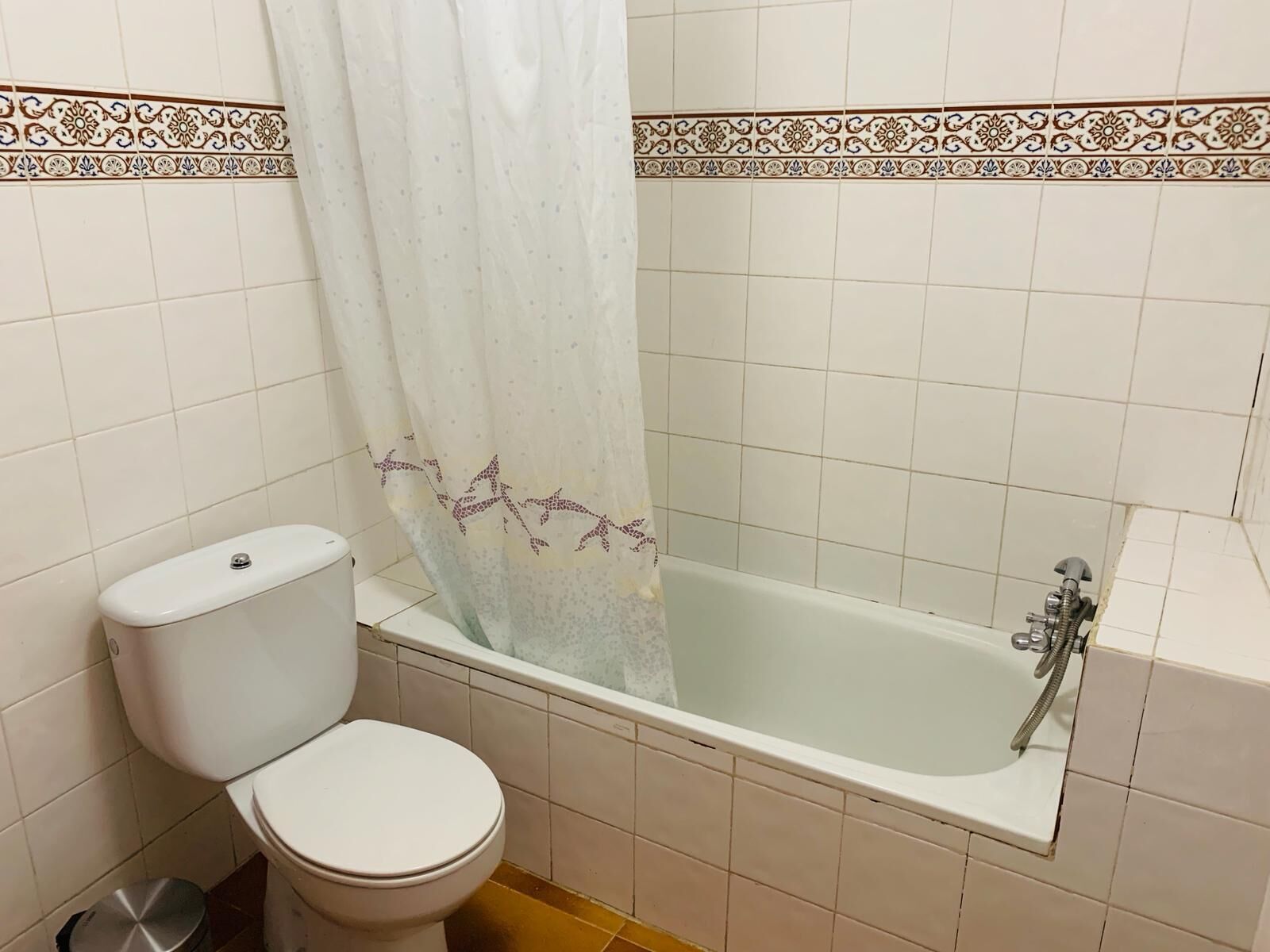 Un baño con inodoro, bañera y ducha.