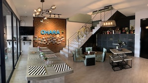 Un intérieur moderne comprenant un bar, des sièges, un escalier et un mur en briques orné de photos.