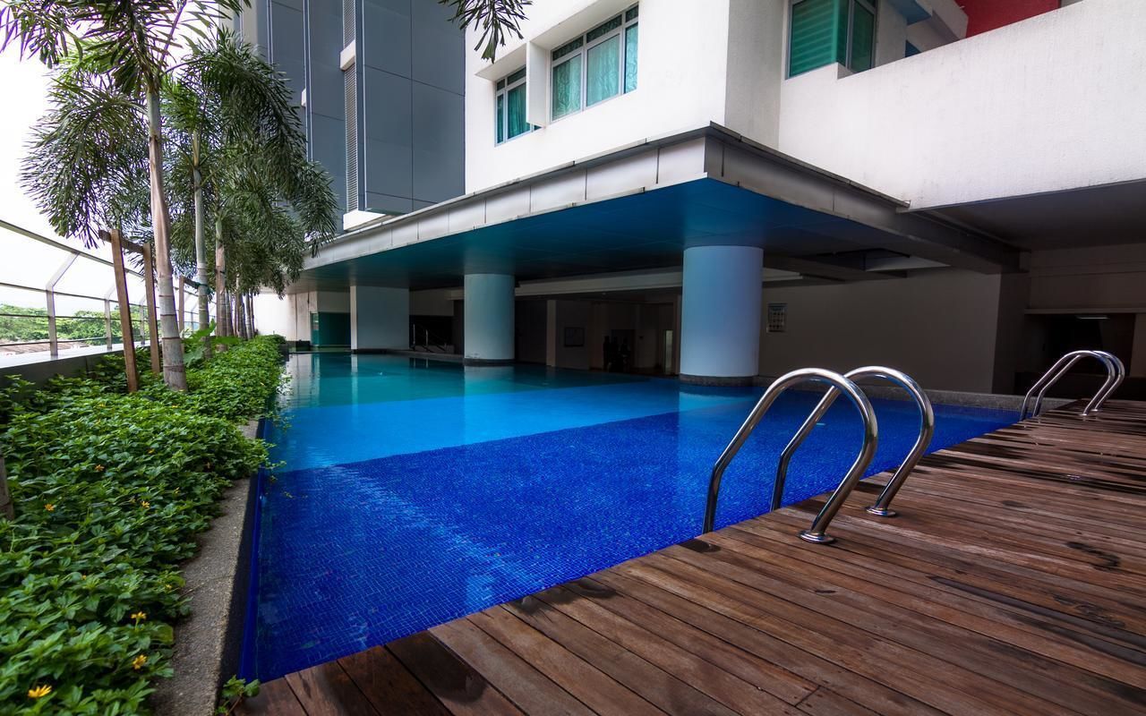 An indoor swimming pool with a wooden deck and palm trees.