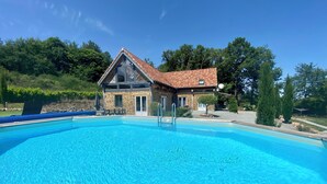 Una piscina con un edificio de piedra al fondo.