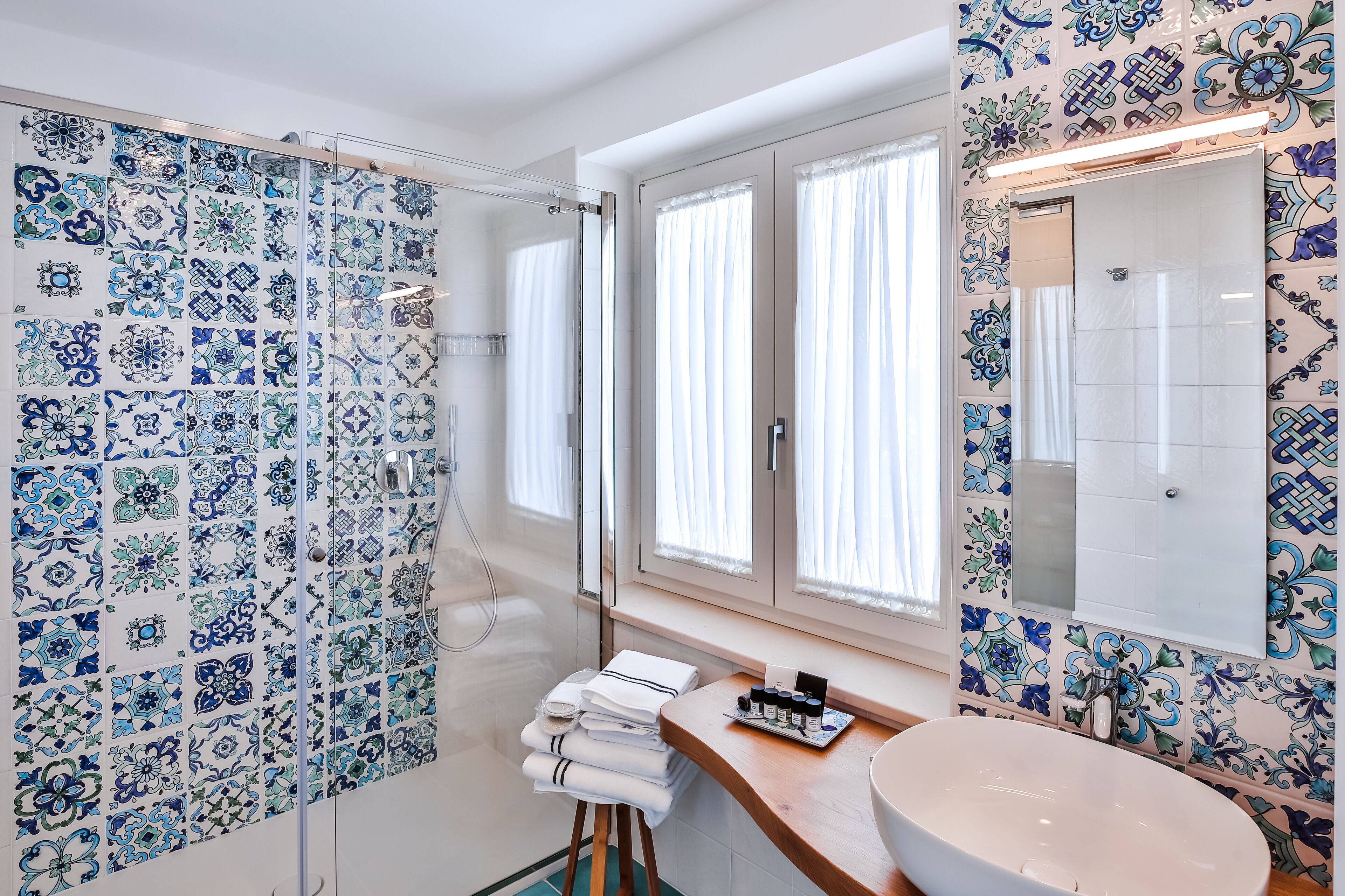 A bathroom with a shower, a sink, and a mirror.