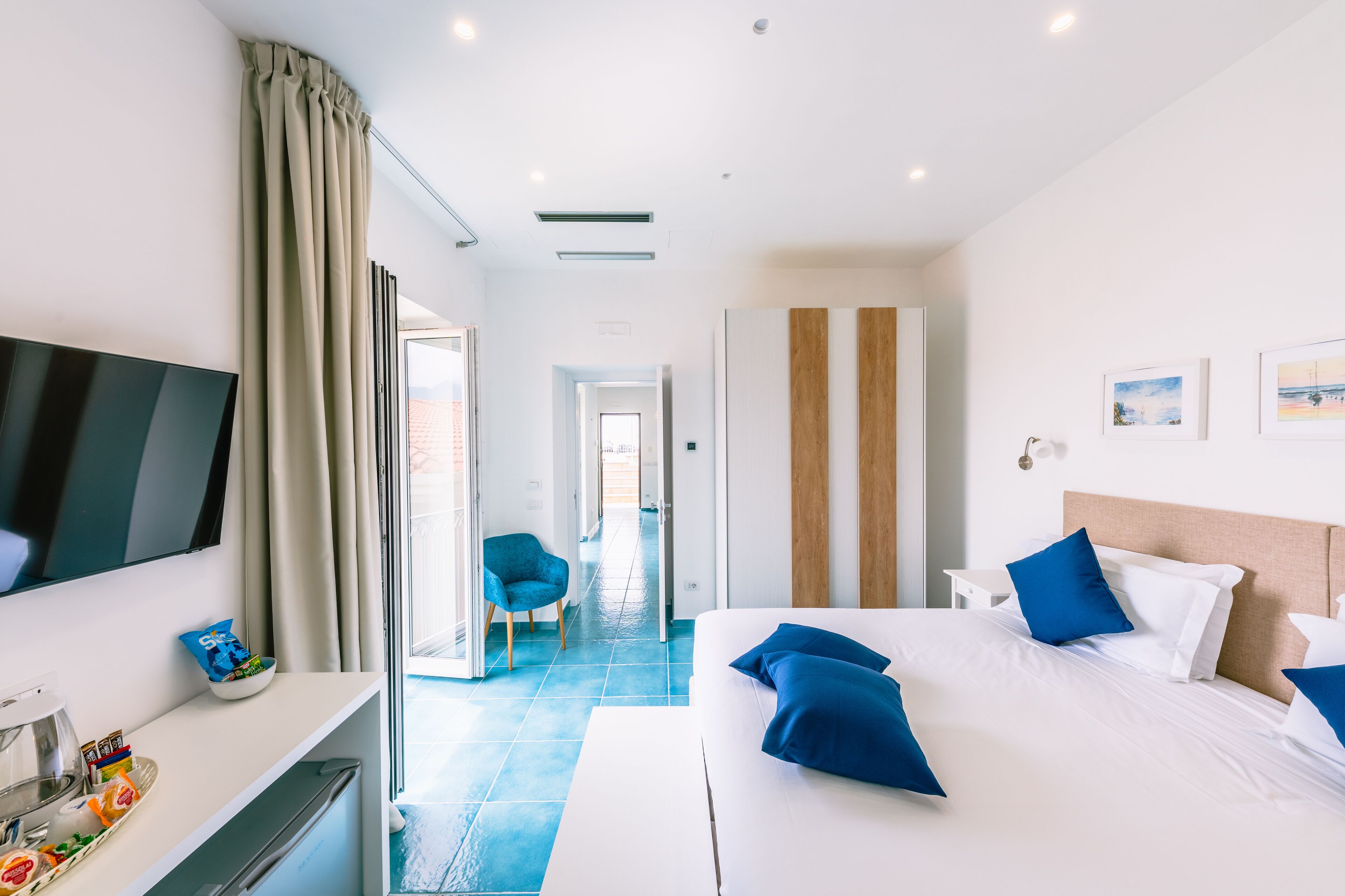 Une chambre d’hôtel moderne dotée d’un grand lit, d’une télévision à écran plat, d’un bureau avec un ordinateur et d’une chaise.