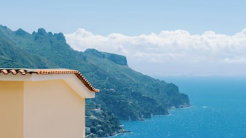 Vista costera con casas escalonadas en una ladera con vista al mar.