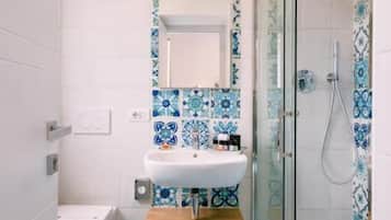 A bathroom with a white sink, a toilet, and a shower area.