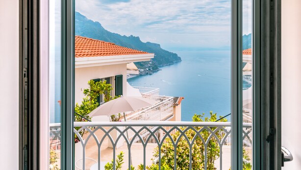 Un balcón con vista al mar y a las montañas.