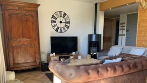 A living room with a large wooden cabinet, a television, a fireplace, and a sofa. - New! Superb apartment of 90 m2 in the heart of Font Romeu (Font-Romeu-Odeillo-Via)